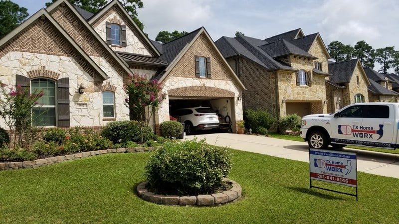 Elegant brick house with landscaped yard and garage.