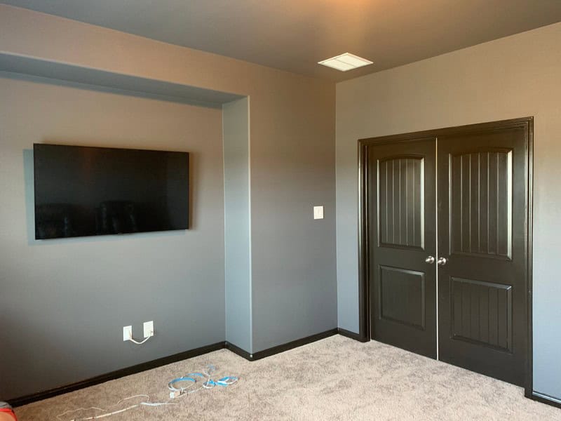 Wood Staining Services 16 Interior room with wall-mounted TV and double closet doors.
